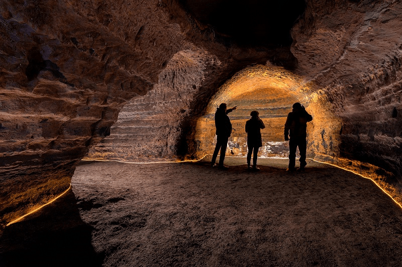 People exploring man-made caves of south Iceland