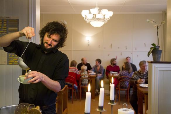 Man getting himself a soup in a hostel in Iceland. Hostels in Iceland are a great choice for the international traveler.