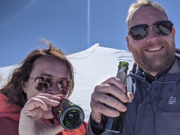 Woman and man with champagne bottles on Snæfellsjökull glacier in Iceland.