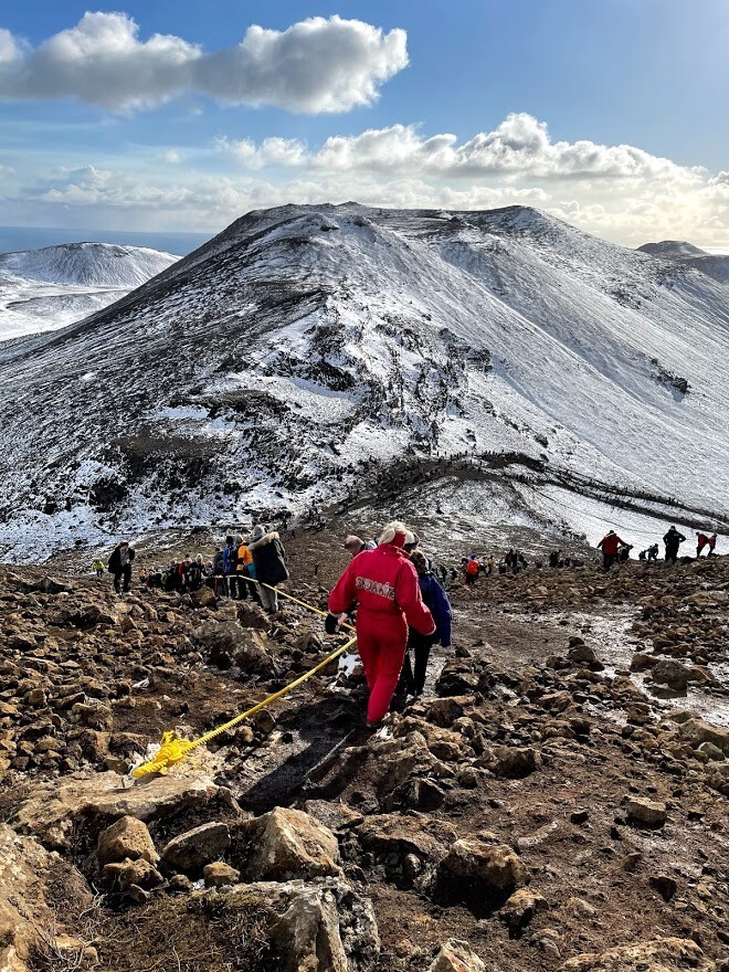 People hiking toward the eruption