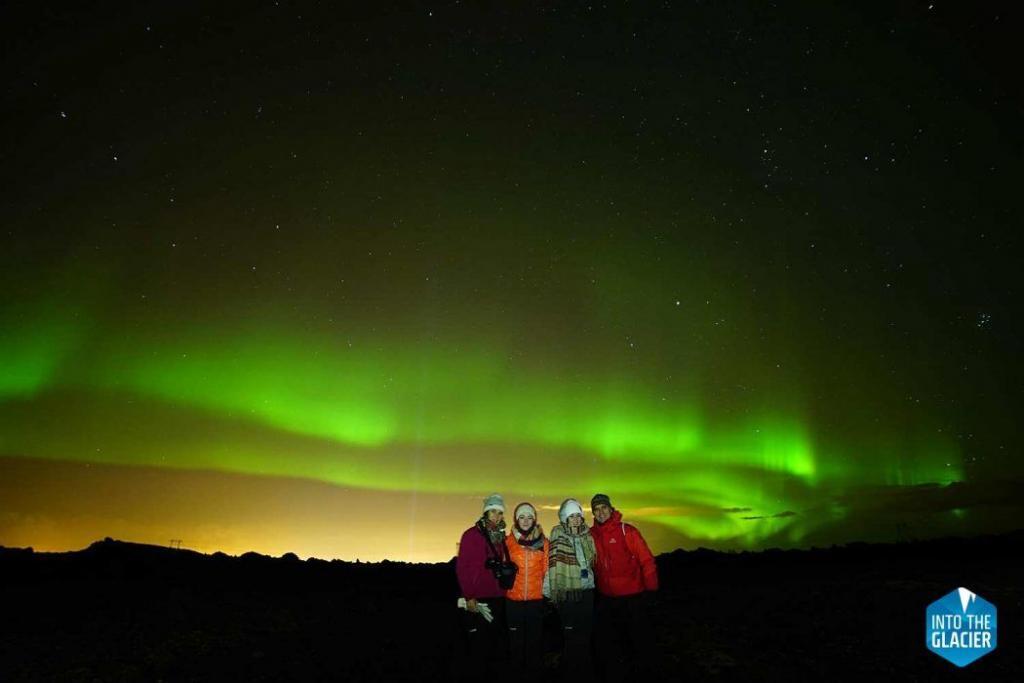 People viewing northern lights in Langjökull in Iceland.