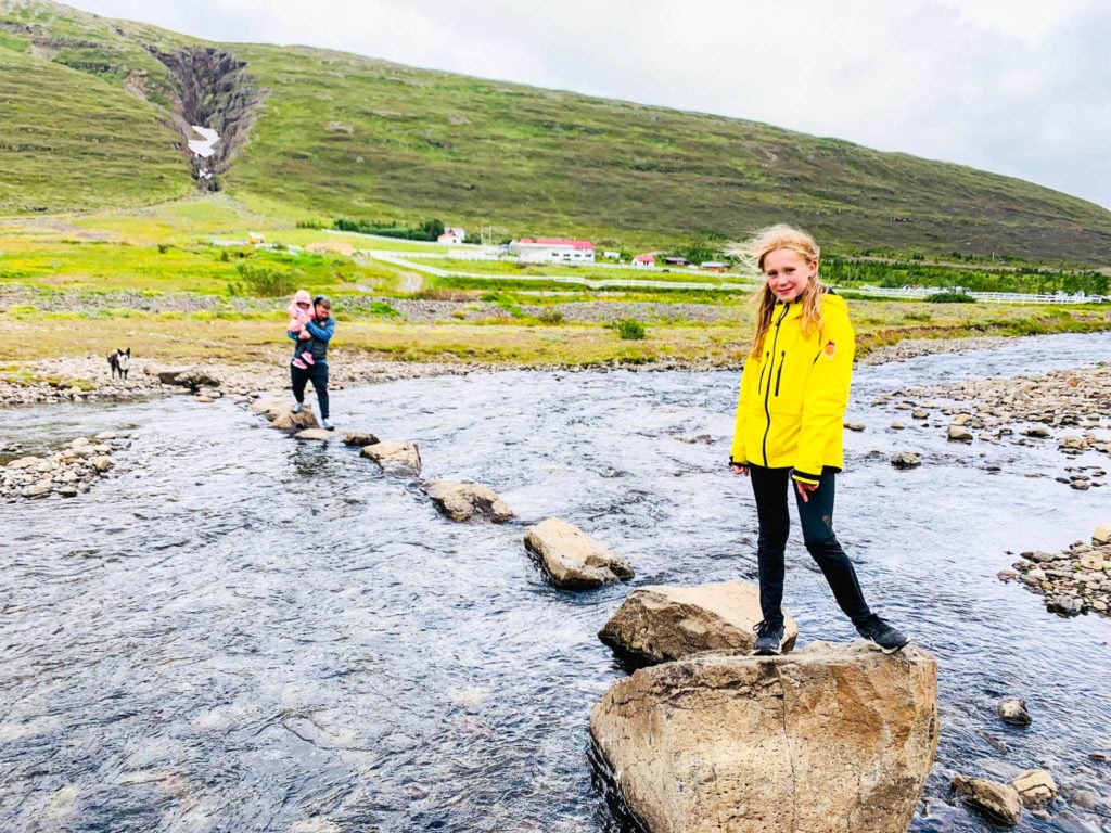 Girl crossing a river in Iceland.