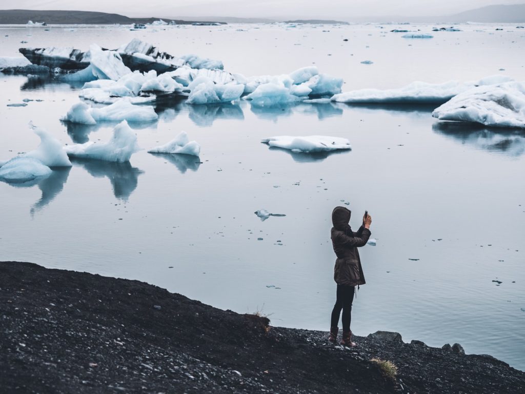 The subject of this article is how to dress in Iceland. The photo shows a lady by the Glacial Lagoon in Iceland.