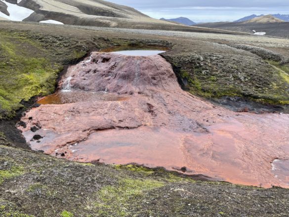 Water streams into the red riverbed at Rauðauga, the source of the Rauðukvísl river in the Icelandic highlands.