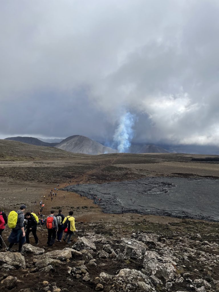 People walking towards the volcanic eruption in Iceland in 2022.
