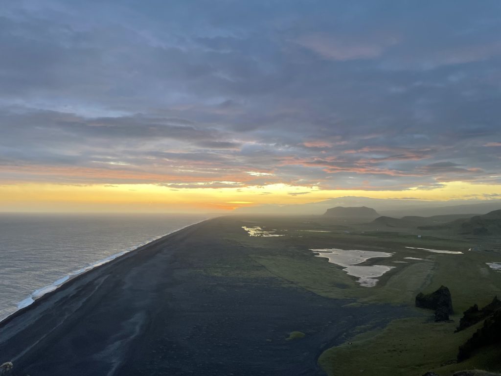 Sunset over black sands as seen from the Dyrhóley promontory in the south of Iceland.