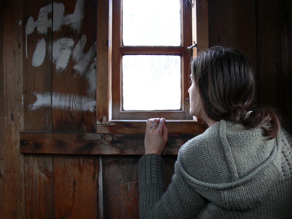 Sarah Thomas looks out of a window in Ísafjörður.