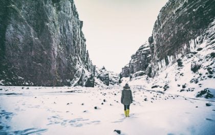 Traveler in rented outdoor clothing watching the northern lights in Iceland — rent outdoor clothes with the Iceland Cover discount code.