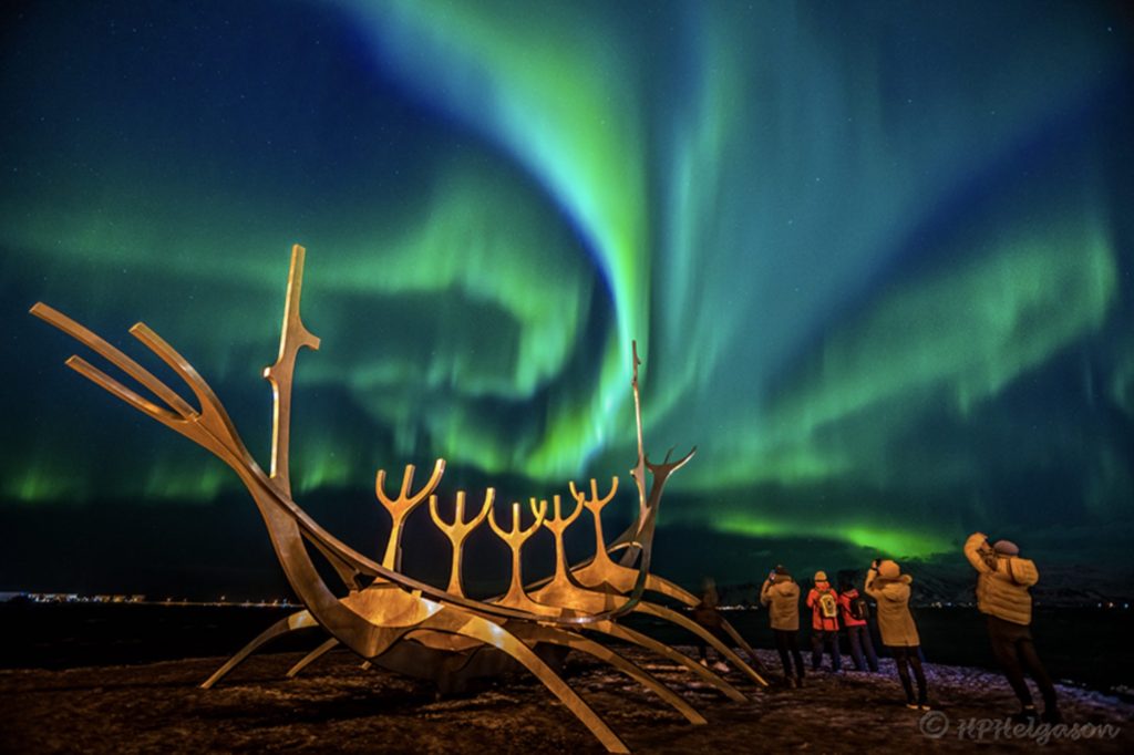 Stunning northern lights are seen from the beautiful Sun Voyager sculpture by the sea side in Reykjavik.