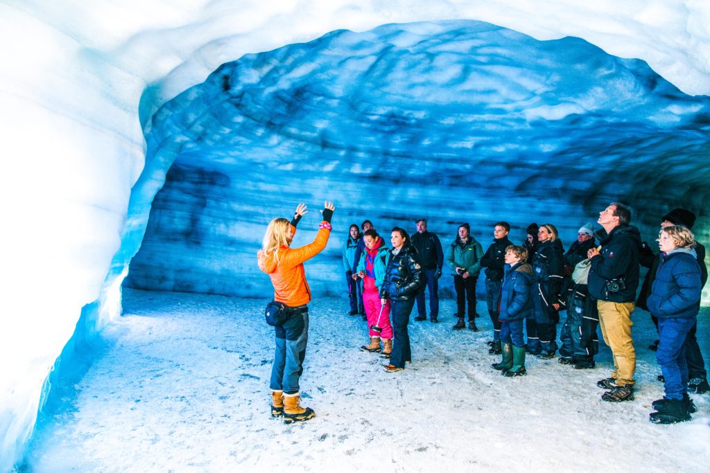 A group of people listens to a guide inside the Langjökull ice tunnel