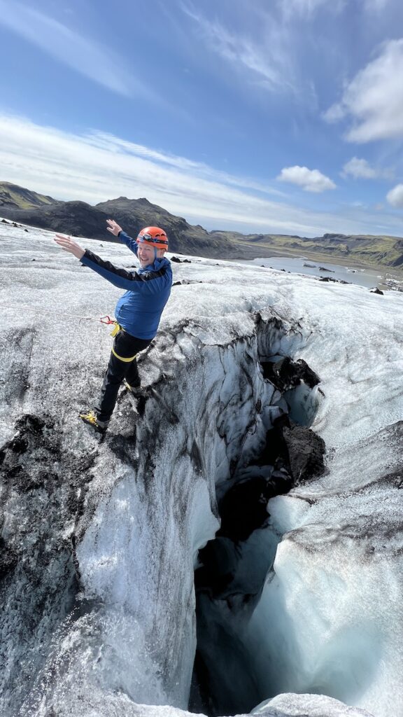 Man leaning back over a crevasse at Langjökull glacier in Iceland.