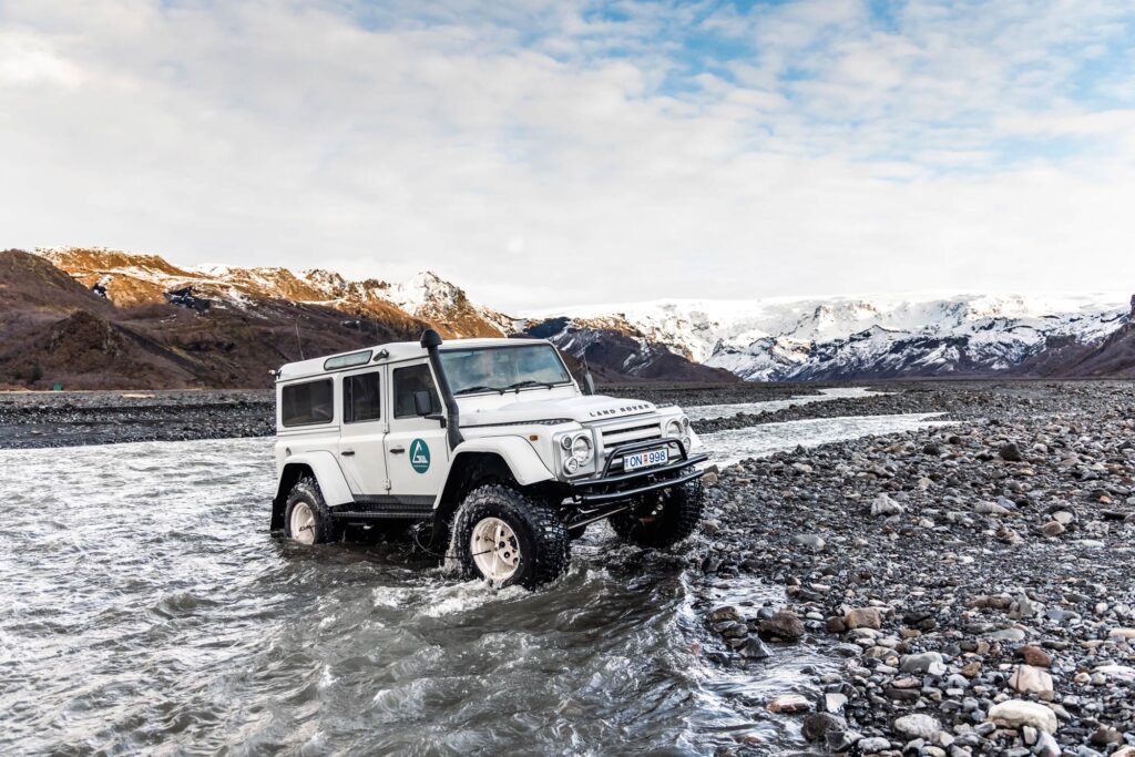 A superjeep crosses a glacial river in Iceland
