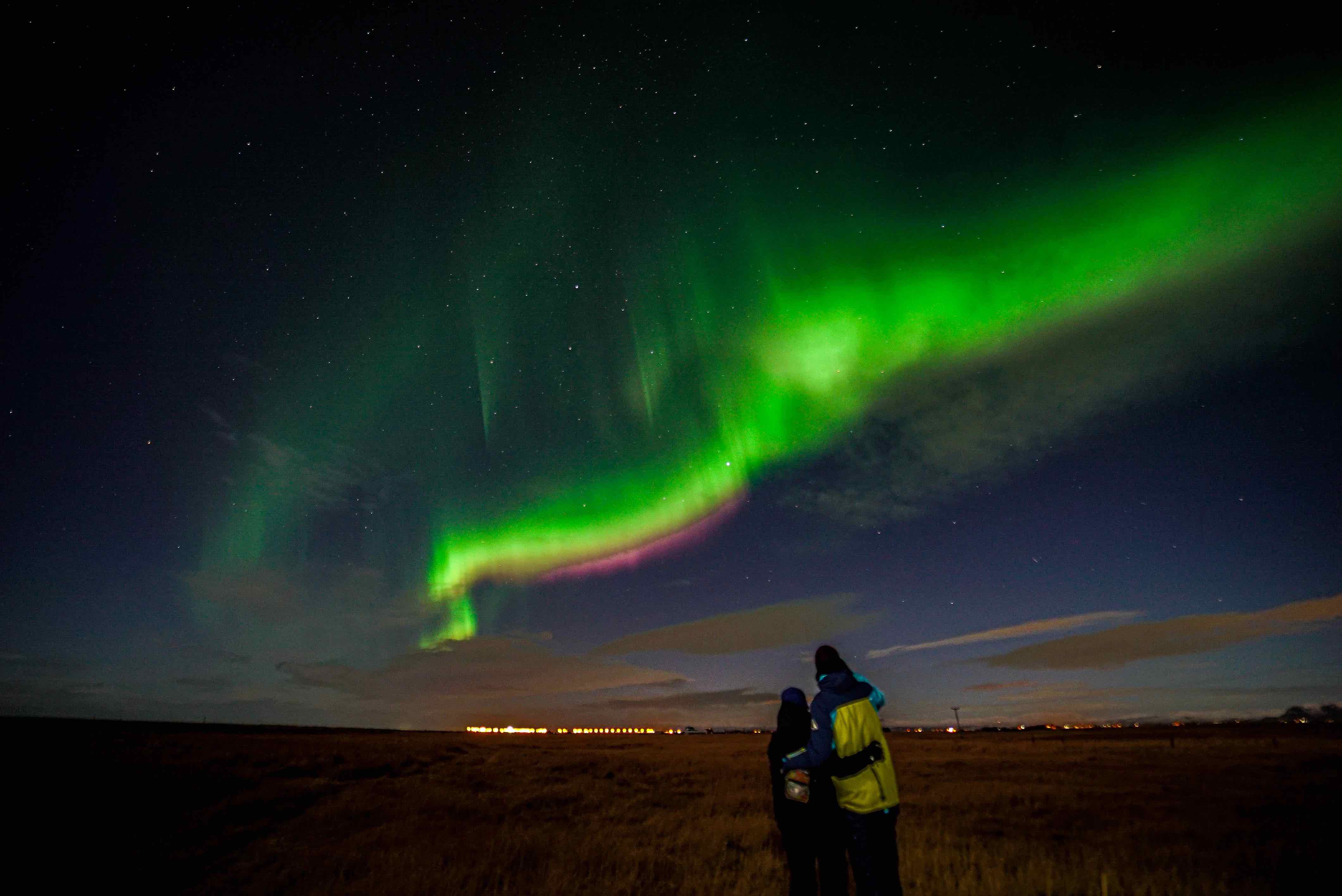 Northern lights over a snow-covered Icelandic landscape away from city lights, seen on a tour with Gravel Travel.