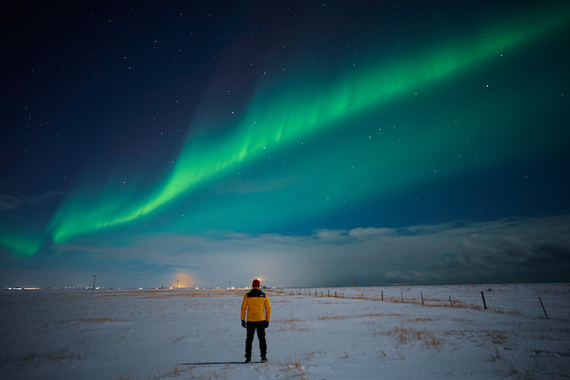 A man watches the northern lights in Iceland.