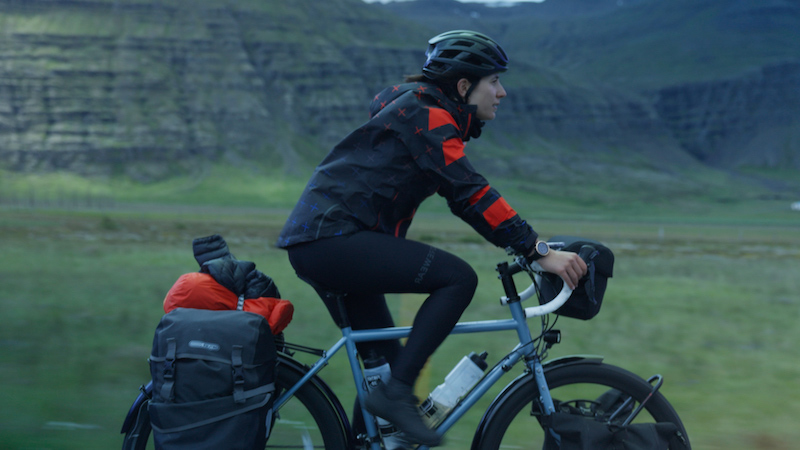 Woman cycling on an Icelandic highway.