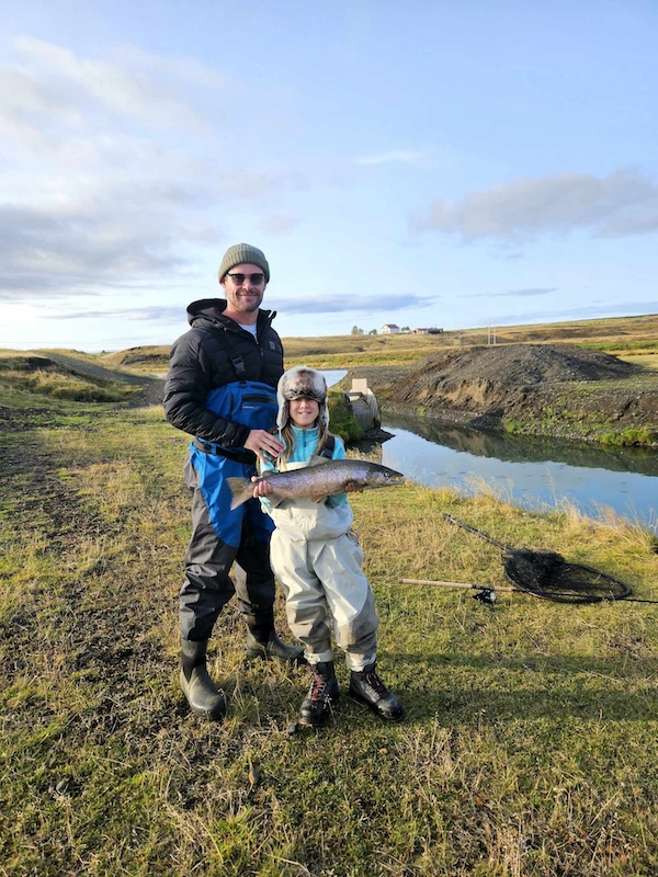Australian actor Chris Hemsworth with his daughter, who is holding a salmon she caught.