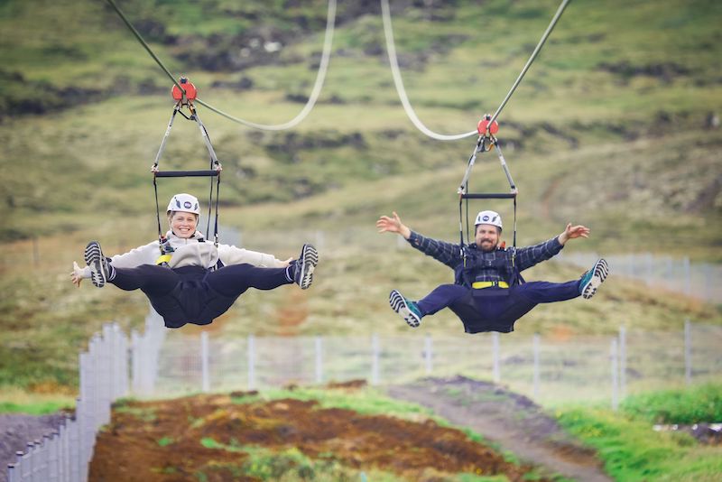A young woman and a young man finish a zipline tour in Iceland.