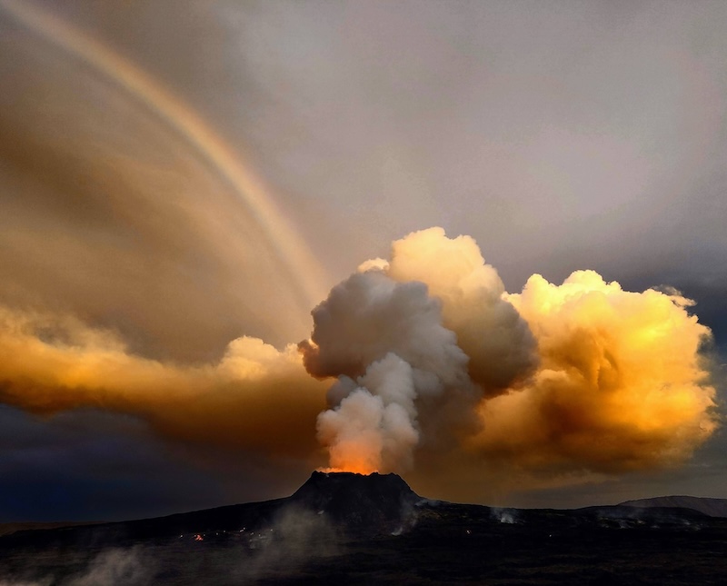 A rainbow is seen behind an erupting volcano in Iceland.