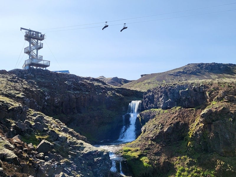 People in a zipline over a canyon in Iceland.