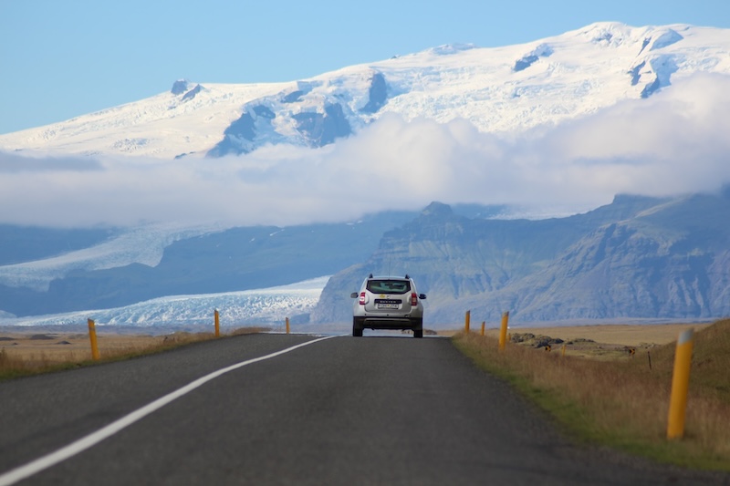Car on a highway in Iceland. Vatnajökull glacier in the background.