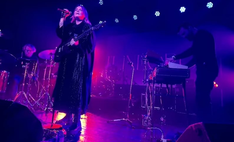 Faroese singer Elinborg performs on a stage with her band.