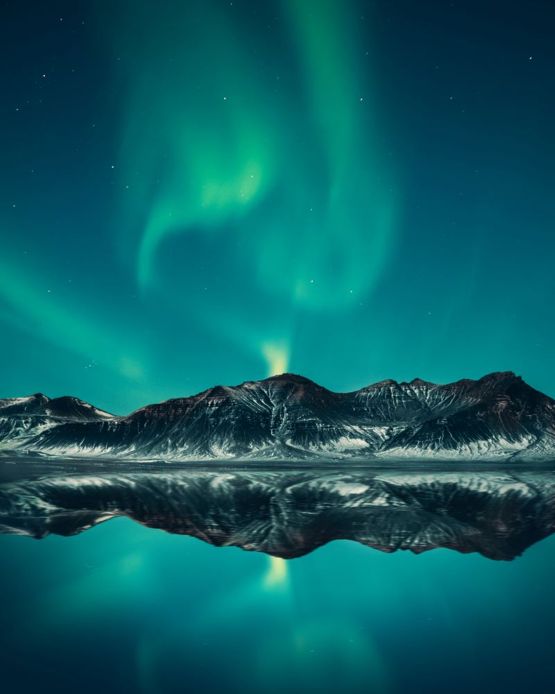 The northern lights above mountains in Iceland.