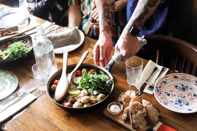 Foodies love Reykjavik food walk culinary adventure. The picture shows a pan of fish being served on a table at a restaurant.