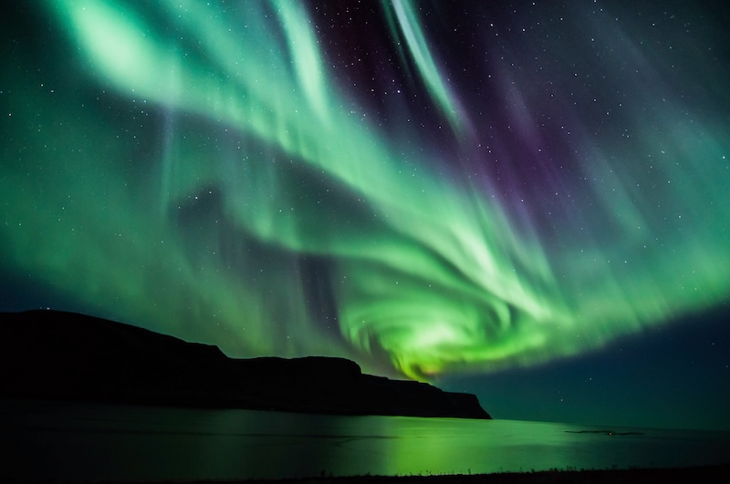 Northern lights shimmer over Iceland. Photo by Mike-Hubert on Shutterstock.