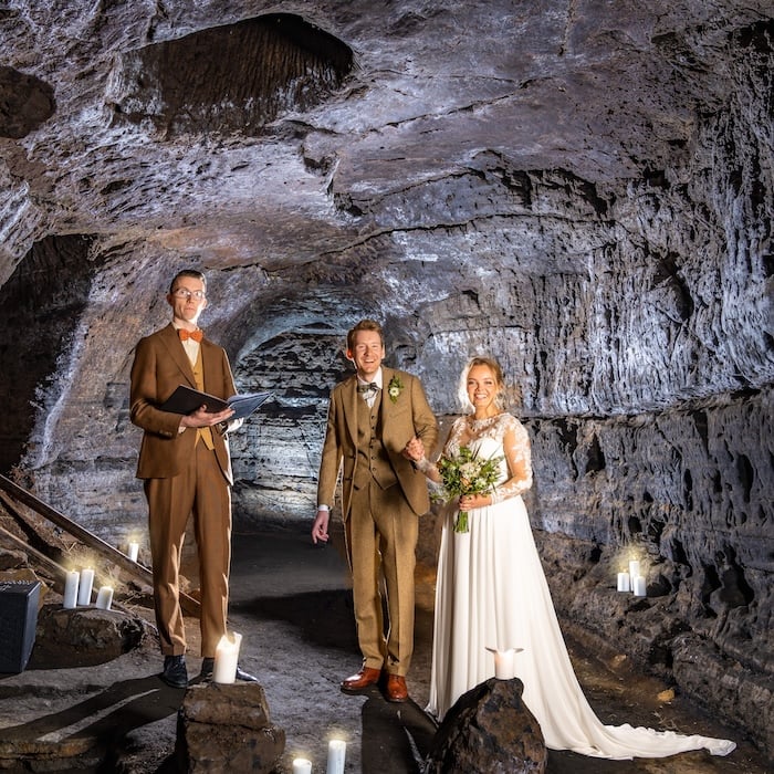 A happy groom and bride at the caves of Hella in Iceland.