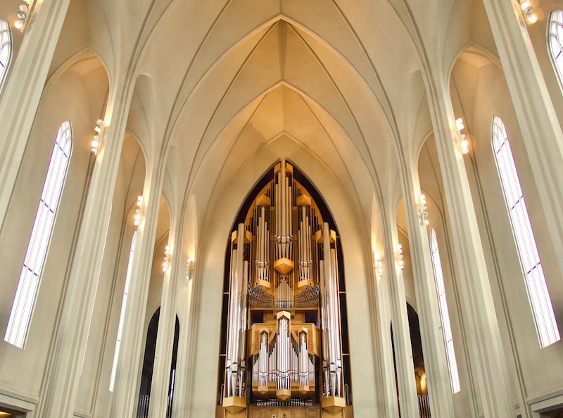 The breathtaking interior of Hallgrímskirkja in Reykjavík, Iceland, showcasing its soaring vaulted ceilings and the grand 5,275-pipe organ—one of the largest in Europe.