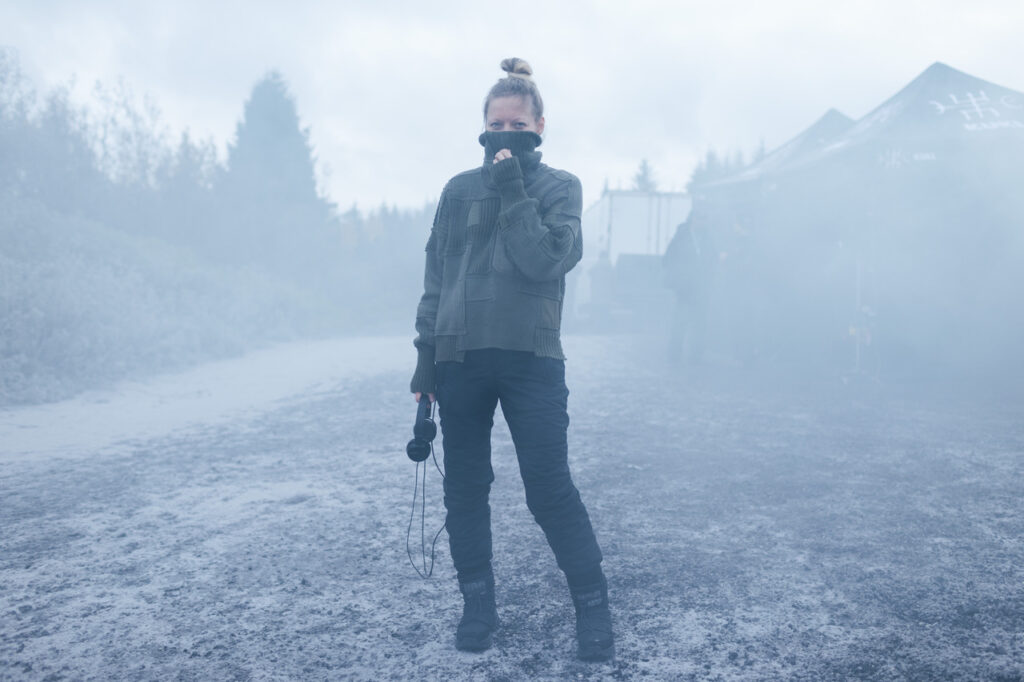 Director Ugla Hauksdóttir on the ash-covered set of The Fires, standing in volcanic haze during filming of the Icelandic disaster drama based on the bestselling novel.
