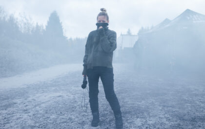 Director Ugla Hauksdóttir on the ash-covered set of The Fires, standing in volcanic haze during filming of the Icelandic disaster drama based on the bestselling novel.