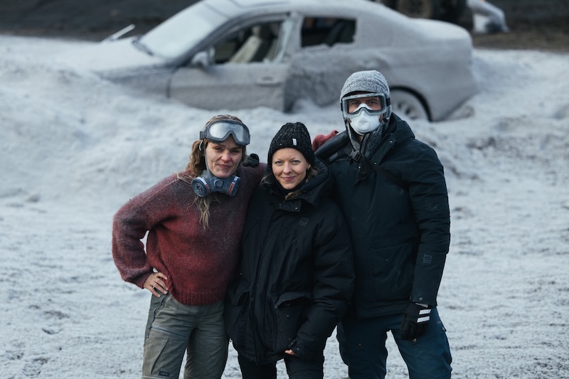 Director Ugla Hauksdottir with actors Vigdís Hrefna Pálsdóttir and Markus Englmair on the ash-covered set of the Icelandic disaster film The Fires.