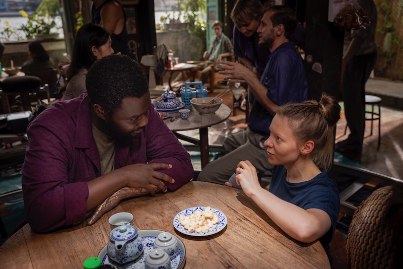 Actor Babou Ceesay, who plays Morrow in Alien Earth, in conversation with director Ugla Hauksdottir on set, seated at a table with tea and snacks.