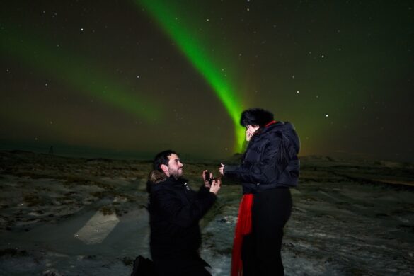 A man proposes to a woman under the aurora in Iceland. They are on a Northern Lights Tours with Gravel Travel.