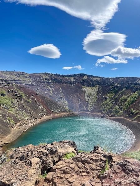 Kerid volcanic crater lake with turquoise water surrounded by red and black volcanic rock walls on Iceland's Golden Circle route