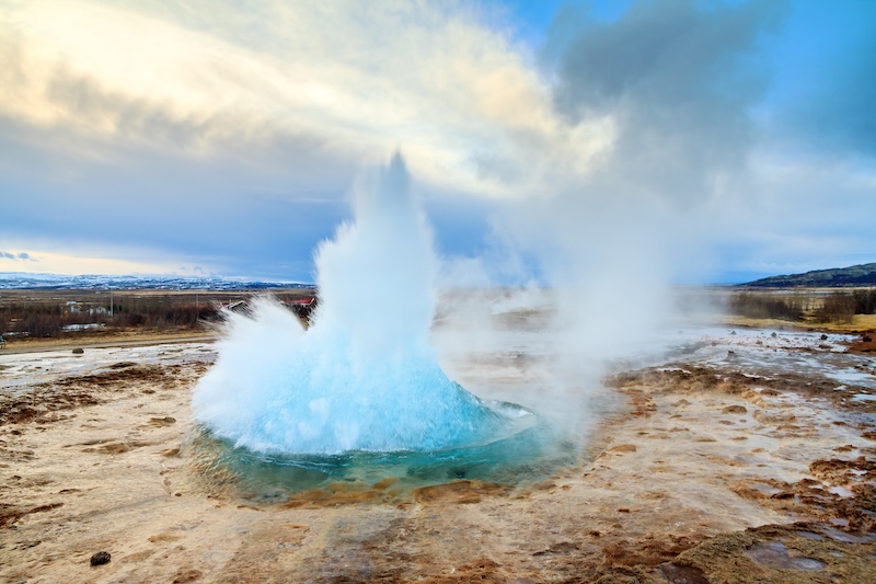 Strokkur geyser erupting with boiling water shooting up to 30 meters high in Haukadalur geothermal area on Iceland's Golden Circle