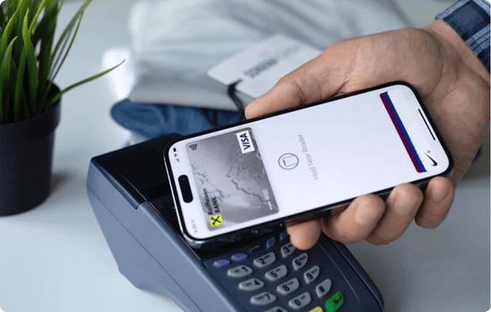 Person using a smartphone to make a contactless Visa payment at a card terminal, demonstrating mobile wallet technology.