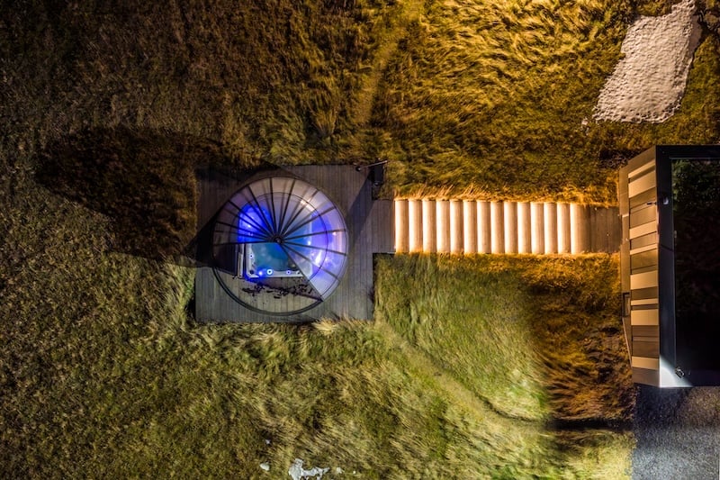 Aerial view of outdoor jacuzzi hot tub with blue lighting at Landhotel spa facilities in South Iceland near Hella