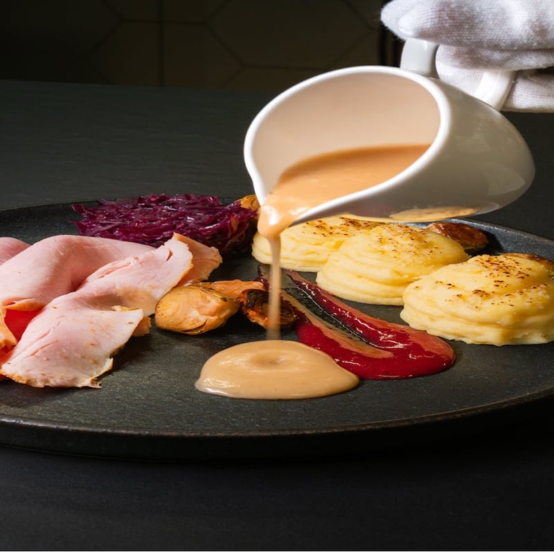 Plated dinner main course at Landhotel restaurant in South Iceland featuring local ingredients with sauce being poured over potato gratin and meat