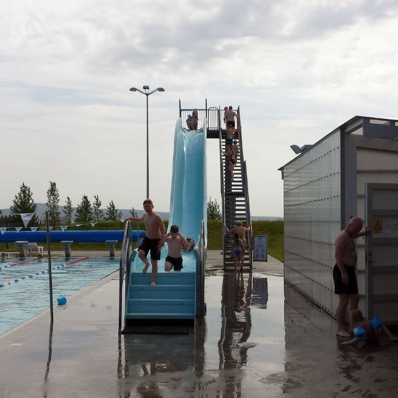 Summer afternoons at Borg swimming pool — geothermal water, a blue slide, and kids who never tire of the climb.
