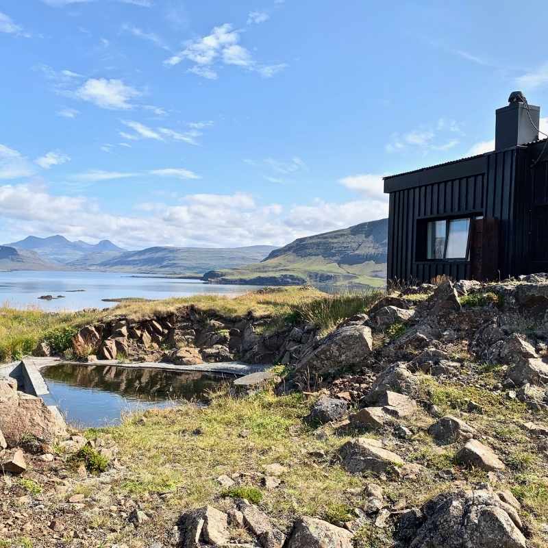 Overnight accommodation at Hvammsvík — a private pool, the fjord at your feet, and the mountains across the water.